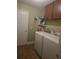 Well-equipped laundry room with washer, dryer, and storage shelving at 2357 Great Harbor Dr, Kissimmee, FL 34746