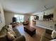 Open-concept living room featuring wood tile flooring, a comfortable sofa, and natural light at 2357 Great Harbor Dr, Kissimmee, FL 34746