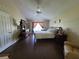Bright main bedroom featuring dark wood floors, ceiling fan and natural light from the window at 2357 Great Harbor Dr, Kissimmee, FL 34746