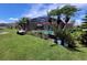 A screened-in pool area, lush greenery and landscaping, and several palm trees fill the backyard at 2357 Great Harbor Dr, Kissimmee, FL 34746