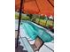 Beautiful in-ground pool with an orange umbrella for shade offers a refreshing escape on warm days at 2357 Great Harbor Dr, Kissimmee, FL 34746