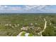 Sprawling wooded landscape surrounds a red house with a tin roof, offering a tranquil retreat with expansive views at 2576 R E Byrd Rd, Frostproof, FL 33843