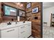 Modern bathroom with double vanity, decorative mirrors, and wood accent wall at 2576 R E Byrd Rd, Frostproof, FL 33843