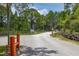 Main community entrance with access gate and signage, set amidst mature trees and green space under a clear sky at 2576 R E Byrd Rd, Frostproof, FL 33843