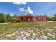 Charming single-story home with solar panels, a wooden deck, and a large front yard at 2576 R E Byrd Rd, Frostproof, FL 33843