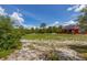 House exterior showing its red siding, front porch, solar panels, and expansive yard at 2576 R E Byrd Rd, Frostproof, FL 33843