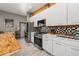 Bright, modern kitchen with stainless steel appliances, white cabinetry and unique tiled backsplash at 2576 R E Byrd Rd, Frostproof, FL 33843