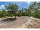 Gravel driveway on expansive lot surrounded by lush trees and natural landscapes at 2576 R E Byrd Rd, Frostproof, FL 33843