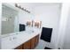 Bathroom featuring double sinks, a large mirror, and a shower with a curtain at 2773 Woodstream Cir, Kissimmee, FL 34743
