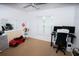 Neutral-toned bedroom featuring a toy car and a workspace with dual monitors at 2773 Woodstream Cir, Kissimmee, FL 34743
