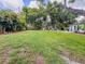 Extensive backyard featuring an expansive lawn, mature trees, and outdoor furniture on concrete patio area at 2900 Wessex St, Orlando, FL 32803