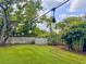 Large backyard with lush green grass, string lights, a storage shed, and mature trees, perfect for outdoor enjoyment at 2900 Wessex St, Orlando, FL 32803