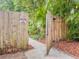 Backyard gate with 'Beware of Dog' sign, opening to a pathway lined with lush foliage at 2900 Wessex St, Orlando, FL 32803