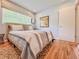 Cozy bedroom with wood floors, striped bedding, and ample natural light from the large window at 2900 Wessex St, Orlando, FL 32803