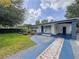 Charming home featuring a blue-accented exterior, complemented by a well-manicured lawn and landscaping at 2900 Wessex St, Orlando, FL 32803