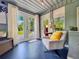 Bright sun room with blue floor, natural light, double doors and neutral chair with a yellow throw pillow at 2900 Wessex St, Orlando, FL 32803
