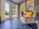 Bright sun room with blue floor, natural light, double doors and neutral chair with a yellow throw pillow at 2900 Wessex St, Orlando, FL 32803
