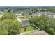 Aerial view of a home nestled among trees in a residential neighborhood, showcasing its fenced-in backyard at 303 Anchovie Ct, Poinciana, FL 34759