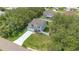 An aerial view of a home surrounded by green trees in a quiet residential neighborhood at 303 Anchovie Ct, Poinciana, FL 34759