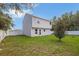 View of a home's backyard featuring a fenced yard with green grass and a young tree at 303 Anchovie Ct, Poinciana, FL 34759