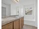 Bathroom features a double vanity, tub, and a window for natural light at 303 Anchovie Ct, Poinciana, FL 34759