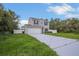 Two-story home with neutral siding, attached garage, and a long driveway at 303 Anchovie Ct, Poinciana, FL 34759