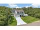 Two-story home with a well-maintained lawn, attached garage, and long, paved driveway at 303 Anchovie Ct, Poinciana, FL 34759