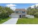 Home featuring a garage, paved driveway, well-kept lawn, and a privacy fence at 303 Anchovie Ct, Poinciana, FL 34759