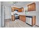 Modern kitchen featuring stainless steel appliances, wood cabinets, and gray countertops at 303 Anchovie Ct, Poinciana, FL 34759