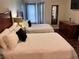 Bright bedroom featuring two beds, dresser, mirror and closet at 3100 Parkway Blvd # 417, Kissimmee, FL 34747