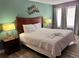 Well-lit bedroom with a king bed, side tables, lamps, and decorative wall art at 3100 Parkway Blvd # 521, Kissimmee, FL 34747