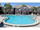 Large, in-ground pool with lounge chairs surrounding it and several buildings in the background at 3100 Parkway Blvd # 521, Kissimmee, FL 34747