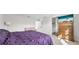 Bright bedroom with a purple comforter, accent furniture, and an adjacent open doorway at 3144 Dark Sky Dr, Harmony, FL 34773
