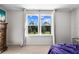Sunlit bedroom with a large double hung window overlooking the lush backyard at 3144 Dark Sky Dr, Harmony, FL 34773
