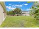 Spacious backyard shows green lawn, plantings, trees and view of fence and neighboring homes at 3212 Preserve Dr, Orlando, FL 32824