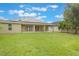 Well-manicured backyard features green grass, landscaping, solar panels, and a fire pit at 3212 Preserve Dr, Orlando, FL 32824