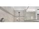 Bathroom featuring a shower stall with a mosaic tile accent, gray tile walls, and a frameless glass partition at 3212 Preserve Dr, Orlando, FL 32824