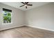 Bedroom featuring a ceiling fan, light gray walls, white trim, light wood-look flooring, and a window to the outside at 3212 Preserve Dr, Orlando, FL 32824