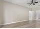 Bedroom featuring a ceiling fan, light gray walls, white trim, light wood-look flooring, and multiple doors at 3212 Preserve Dr, Orlando, FL 32824
