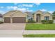 Charming, single-story home featuring a two-car garage and lush landscaping at 3212 Preserve Dr, Orlando, FL 32824