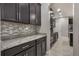 Modern kitchen with dark wood cabinets, stainless steel appliances, and gray backsplash at 3212 Preserve Dr, Orlando, FL 32824
