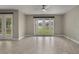 Bright living room featuring neutral paint, tile floors, and French doors to a green backyard at 3212 Preserve Dr, Orlando, FL 32824
