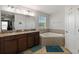 Bathroom with double sinks, granite countertops, soaking tub and walk in shower at 3221 Bayflower Ave, Harmony, FL 34773