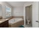 Relaxing bathroom features a large soaking tub with tile surround and a separate toilet area at 3221 Bayflower Ave, Harmony, FL 34773