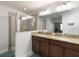 Bright bathroom features a double sink vanity with granite countertops and a glass-enclosed shower at 3221 Bayflower Ave, Harmony, FL 34773