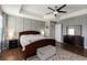 Spacious primary bedroom with tray ceilings, hardwood floors, and a ceiling fan at 3221 Bayflower Ave, Harmony, FL 34773