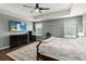 Spacious bedroom featuring hardwood floors, tray ceiling and a ceiling fan at 3221 Bayflower Ave, Harmony, FL 34773