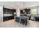 Kitchen with a large island, granite countertops, dark cabinets, and stainless-steel appliances at 3221 Bayflower Ave, Harmony, FL 34773