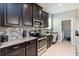 Modern kitchen features dark cabinetry, stainless steel appliances, granite countertops, and tile backsplash at 3221 Bayflower Ave, Harmony, FL 34773