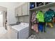 Well-organized laundry room includes washer, dryer, storage cabinets, and a convenient hanging area at 3221 Bayflower Ave, Harmony, FL 34773